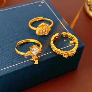 Detailed view of vintage gold rings with zircon flowers on a textured blue gift box