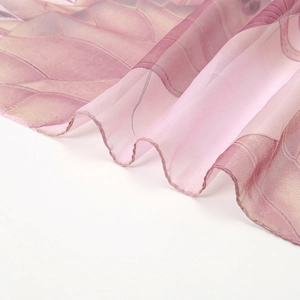 Detailed close-up of pink and purple floral chiffon scarf fabric with delicate hemmed edge