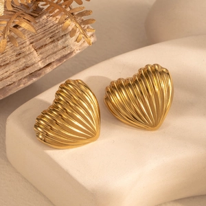 Textured gold heart-shaped stud earrings with wavy patterns on a geometric stand