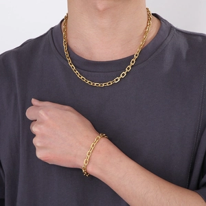Close-up of minimalist gold-tone rectangle link chain necklace and bracelet set on model
