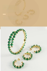 Detail view of gold-plated jewelry set featuring square-cut emerald green zircons