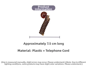 Detail of 7.5cm coffee spiral hair tie with amber bead showing elastic plastic texture