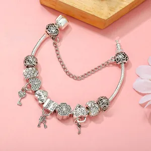Close-up of silver-plated snake chain bracelet with heart, key, and LOVE charms