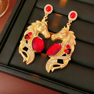 Nahaufnahme der Vintage-Pferdekopf-Ohrringe in Gold mit roten Steinen und Kristallen