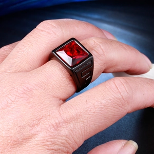 Macro shot of a vintage black stainless steel ring with a large square red gemstone