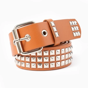 Détail de ceinture en cuir marron avec trois rangées de clous pyramide et boucle en métal