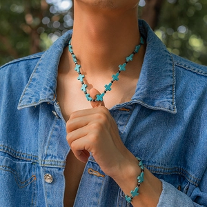 Detail of male model wearing turquoise cross charm necklace and bracelet set