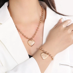 Rose gold heart pendant jewelry set with diamond accents on a bead chain necklace