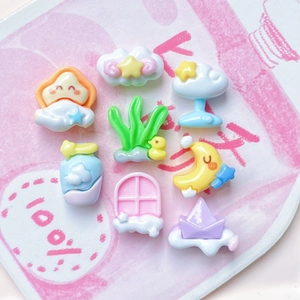 Flat lay of colorful mini resin charms featuring moon, star, clouds and duckling shapes