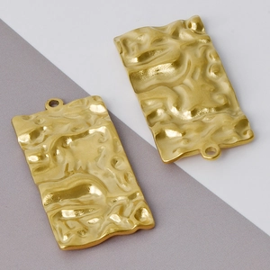 Close-up of golden rectangular stainless steel pendants with hammer texture finish