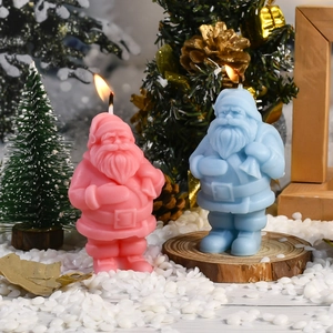 Detailansicht der rosa und blauen Weihnachtsmann-Kerzen in festlicher Winterumgebung