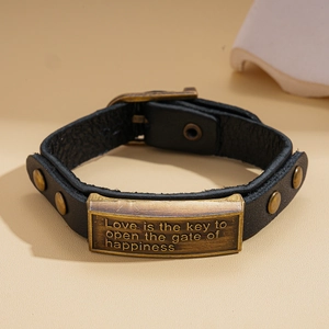 Macro detail of retro black leather bracelet with bronze plaque and metal studs
