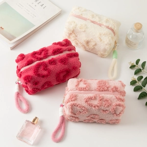 Detail showing heart-patterned plush makeup bags in cream, watermelon, and pink colors