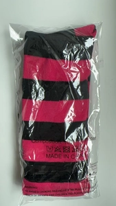 Detail of pink and black striped thigh-high knit socks in protective plastic packaging