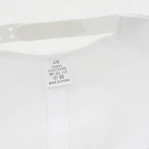 Detail of the white cotton baseball cap showing the plastic strap and 100% cotton label