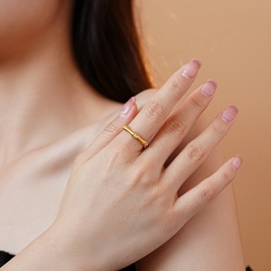 Close-up of bamboo style gold ring with zircon stones on finger for elegant look
