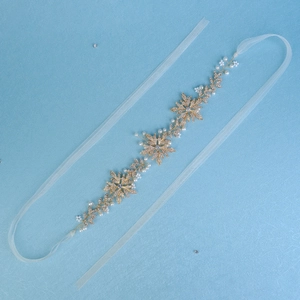 Close-up of golden floral bridal headband with metal leaves, pearls and crystals