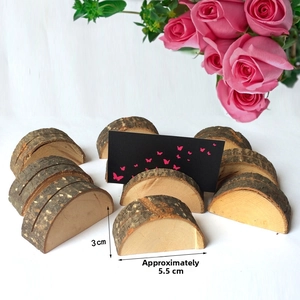 Detail of a natural wood card holder with a butterfly card and pink flowers on white