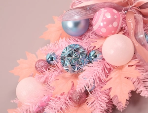 Dettaglio di decorazioni natalizie rosa e blu con nastro Just for you e foglie di acero