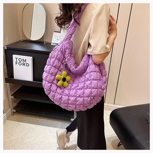 Detail of purple quilted puff tote bag with a yellow sunflower charm and soft nylon texture