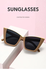 Detail view of cat-eye sunglasses with gold metal trim on a stylish geometric stand