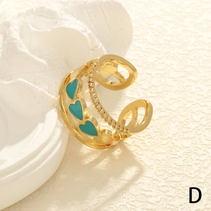 Detail of adjustable gold ring featuring turquoise enamel hearts and cubic zirconia stones