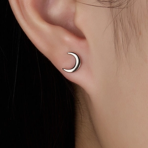 Close-up of minimalist S925 sterling silver crescent moon screw stud earring on ear