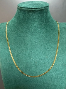 Detailed close-up of a 3mm gold stainless steel curb chain on a green velvet display