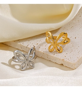 Detail showing gold and silver butterfly rings on a natural stone and silk texture