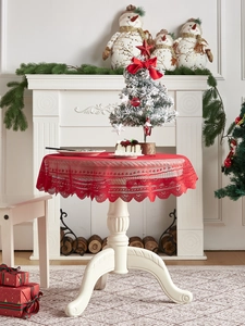 Detail of red lace Christmas tablecloth with heart patterns and scalloped edges for festive decor