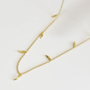 Minimalist 925 sterling silver necklace with gold leaf pendants on white background