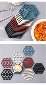 Close-up of geometric hollow silicone coasters in navy, cream, red, and black colors