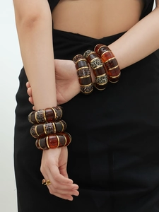 Close-up of leopard print and amber resin elastic bracelet with gold metal rings