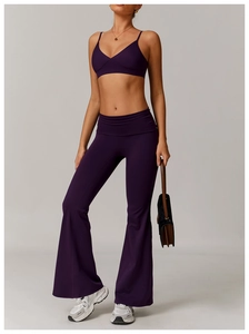 Women's deep purple V-neck sports bra and high-waisted flared yoga set in studio