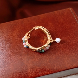 Macro shot of 18k gold plated vintage ring featuring colorful beads and pearl charms