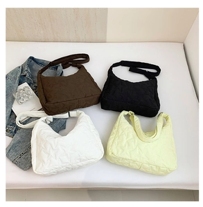 Flat lay of four star-quilted tote bags in brown, black, white, and pale yellow shades