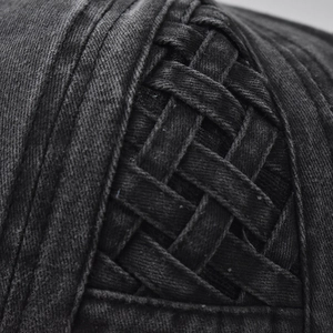 Macro detail of charcoal grey washed denim baseball cap featuring textured woven mesh pattern