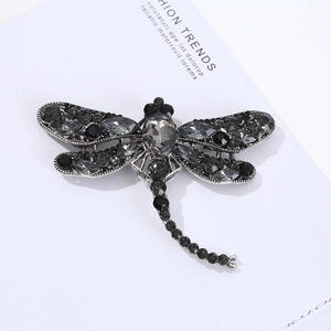 Macro shot of luxury dragonfly brooch with dark grey rhinestones and silver metal