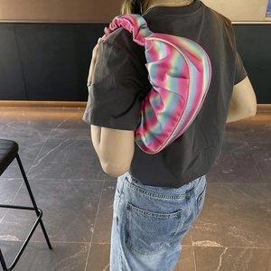 Rainbow gradient pleated shoulder bag shown on shoulder for size and drape perspective