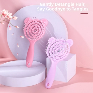 Macro view of purple and pink curved skeleton hair brushes with bear-shaped tops