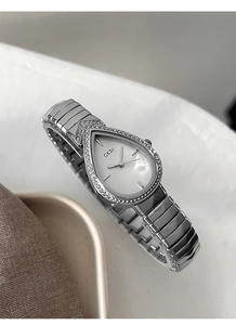 Macro shot of silver teardrop watch dial with rhinestone bezel and polished metal link strap