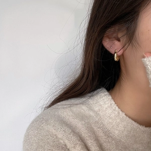 Chunky gold croissant hoop earring in 925 sterling silver worn by model with knitwear