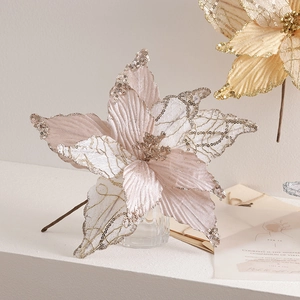 Champagne and pink artificial Christmas flowers with sequins on a clean white surface