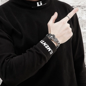 Detail of silver skull cuban link bracelet and ring set for men in punk style