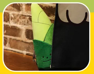 Detail of creative green bamboo shoot plush toy with a cute smiling face on wood table