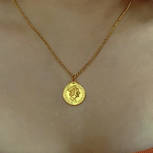Vue détaillée du collier pendentif pièce dorée avec relief Notre-Dame de Guadalupe