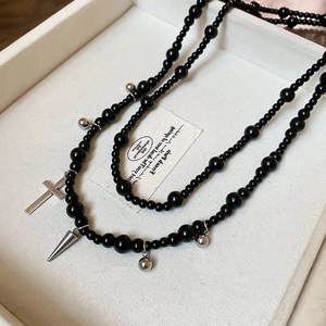 Detail of Y2K black double-layer glass bead necklace with silver cross and metal pendants