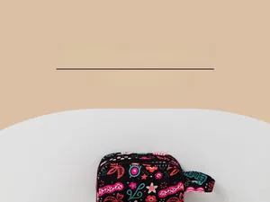 Détail d'une trousse à maquillage double couche à fleurs avec poignée et fermeture