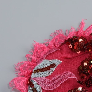 Detailed view of red sequins and fine silk embroidery on floral lace evening dress