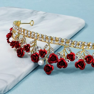 Makro-Detail der goldenen Krone mit roten Rosen, weißen Perlen und Glitzersteinen